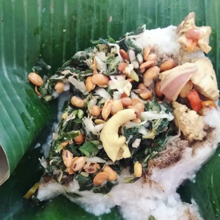 makanan khas bali bernama nasi tepeng disajikan dengan daun pisang